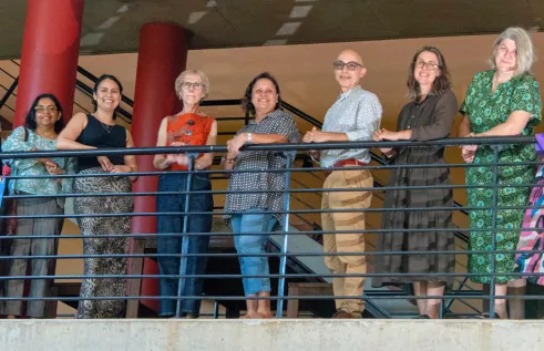 Northern Institute researchers smiling and leaning against bannister